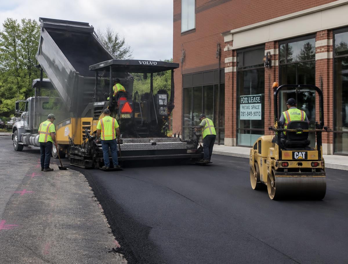 Boston Top Asphalt Paving crew laying hot asphalt on a commercial parking lot